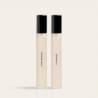 Two cream-colored fragrance rollerballs with black caps labeled "Core Memory" and "7 Summers."