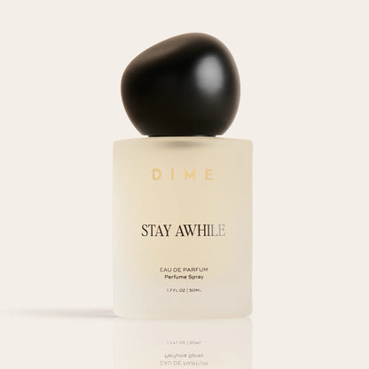 Cream-colored perfume bottle with black spherical cap labeled "Stay Awhile" eau de parfum spray, 1.7 fl oz.