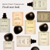 Collection of DIME fragrances in cream and beige bottles with black spherical caps, featuring Malibu Night, Stay Awhile, Core
