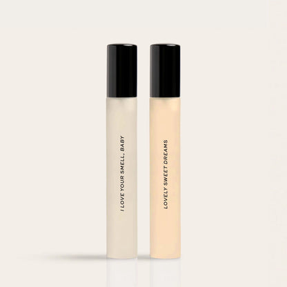 Two rectangular perfume bottles with black caps labeled "I Love Your Smell Baby" and "Lovely Sweet Dreams" in cream and beige