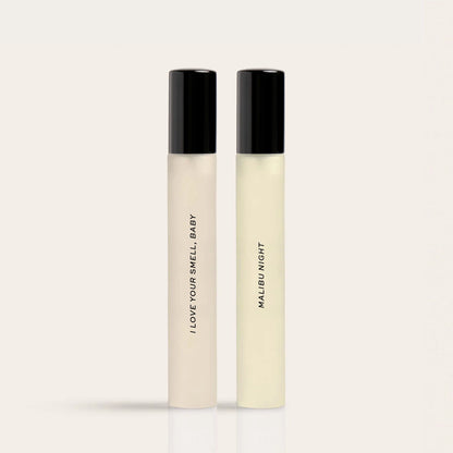 Two rectangular fragrance bottles with black caps labeled "I Love Your Smell Baby" and "Malibu Night" containing pale yellow 