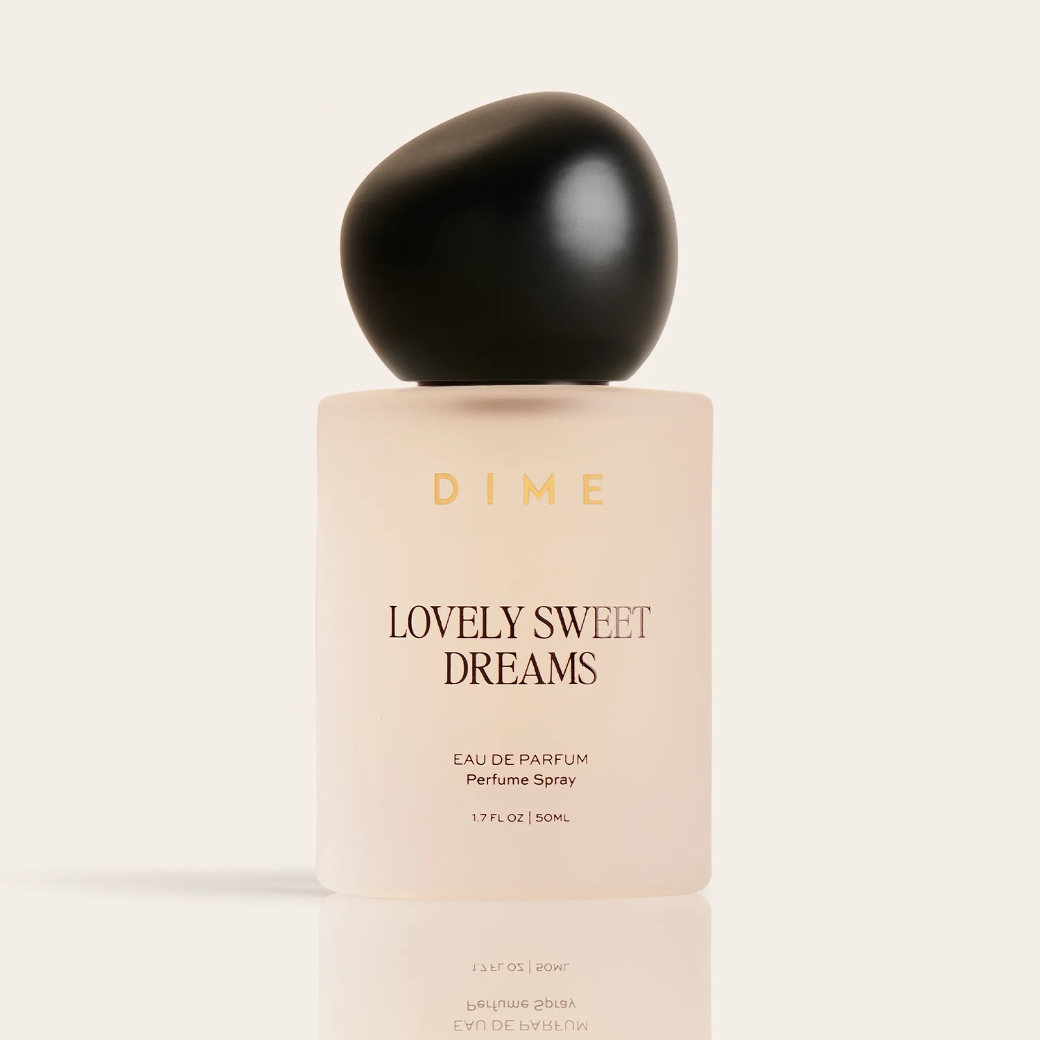Cream-colored perfume bottle labeled "Lovely Sweet Dreams" with black spherical cap, 1.7 fl oz size.