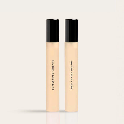 Two cylindrical fragrance bottles with black caps and cream-colored bodies labeled "Lovely Sweet Dreams."