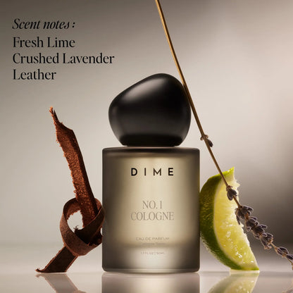 Cylindrical cologne bottle with black spherical cap, surrounded by lime wedge, lavender sprig, and leather texture elements a