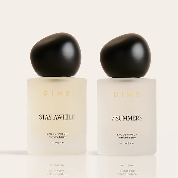 Two DIME eau de parfum bottles labeled "Stay Awhile" and "7 Summers" with black spherical caps, 50ml each.