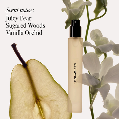 Cream-colored travel spray bottle with black atomizer next to sliced pear and white orchid flowers.