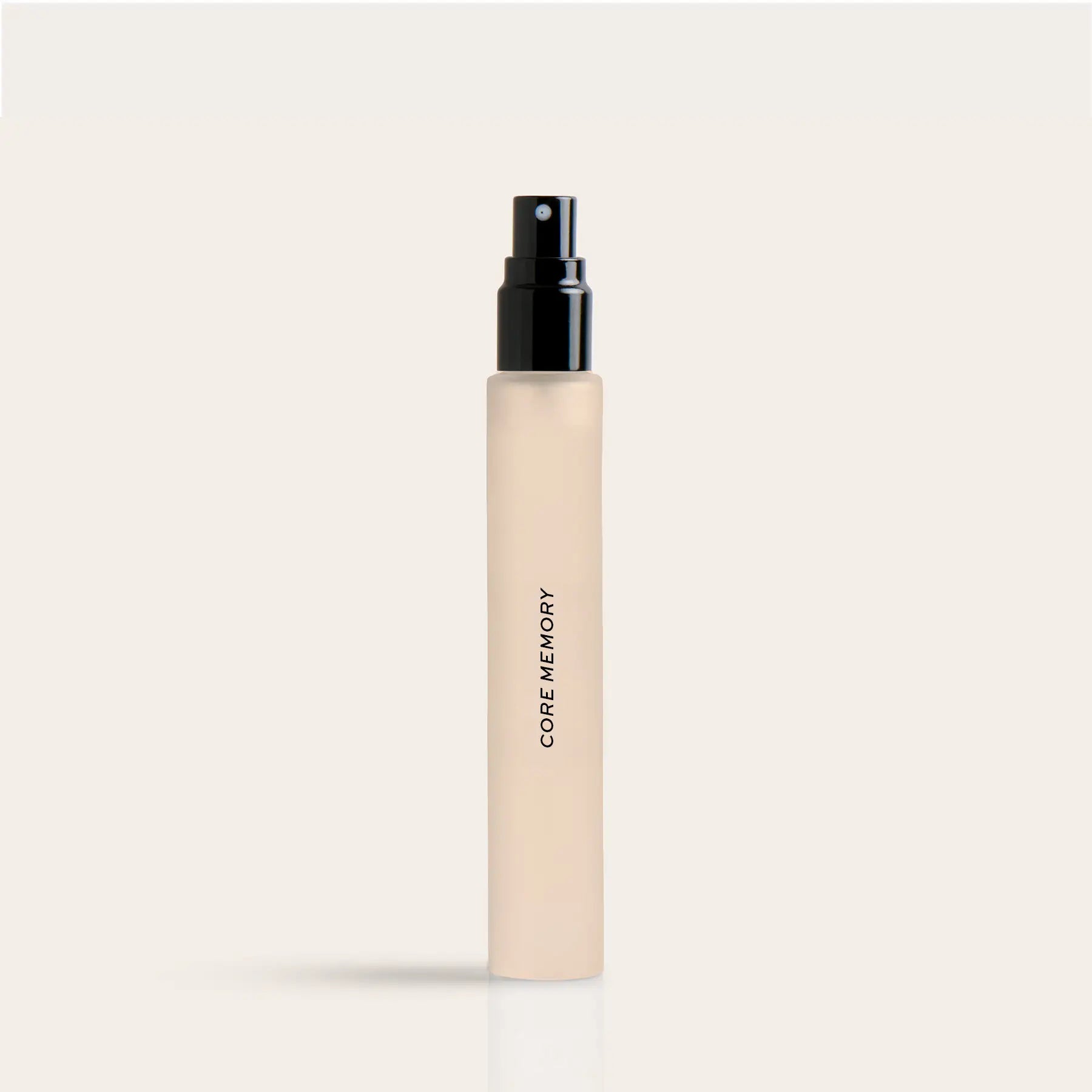Cream-colored travel perfume spray bottle with black pump top and "Core Memory" text on label.