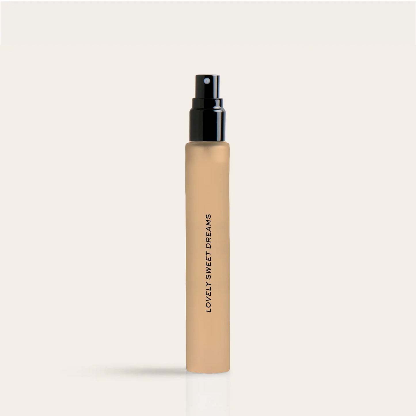 Beige cylindrical perfume travel spray bottle with black spray nozzle and "Lovely Sweet Dreams" text on label.