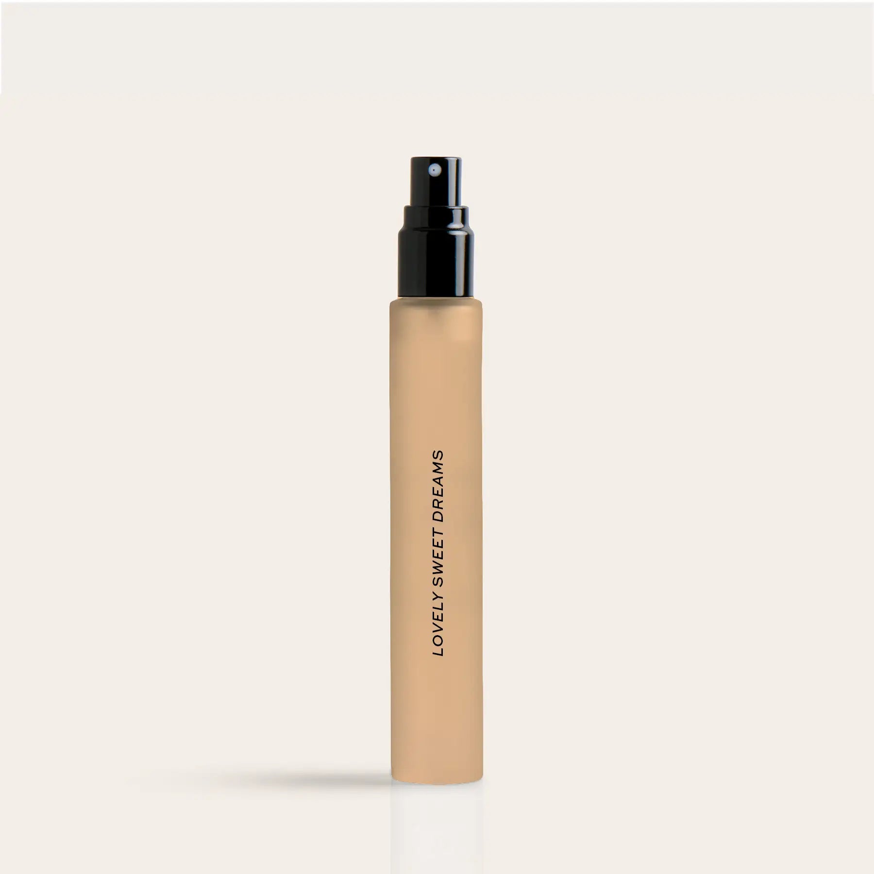 Beige cylindrical perfume travel spray bottle with black spray nozzle and "Lovely Sweet Dreams" text on label.