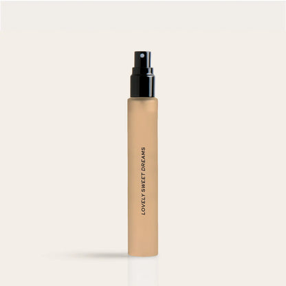 Beige cylindrical perfume travel spray bottle with black spray nozzle and "Lovely Sweet Dreams" text on label.
