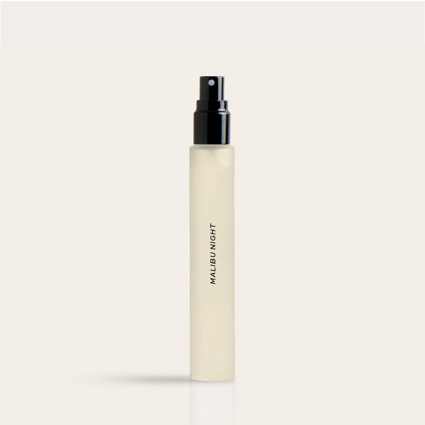 Cylindrical cream-colored perfume spray bottle with black atomizer top and "Malibu Night" text on label.