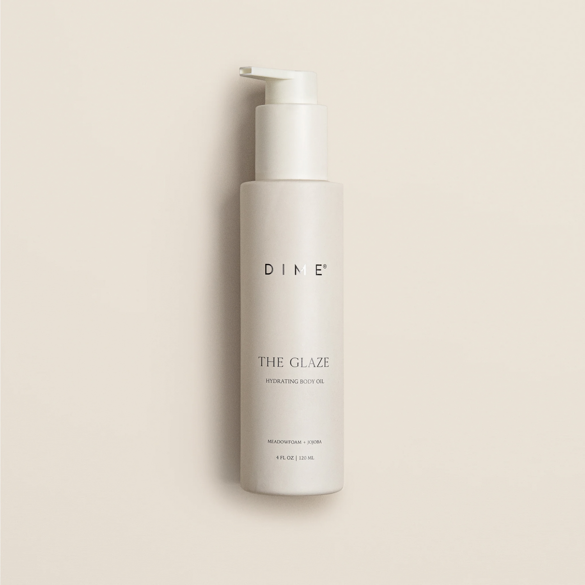 White pump bottle of DINE The Glaze hydrating body oil, 4 fl oz, against beige background.